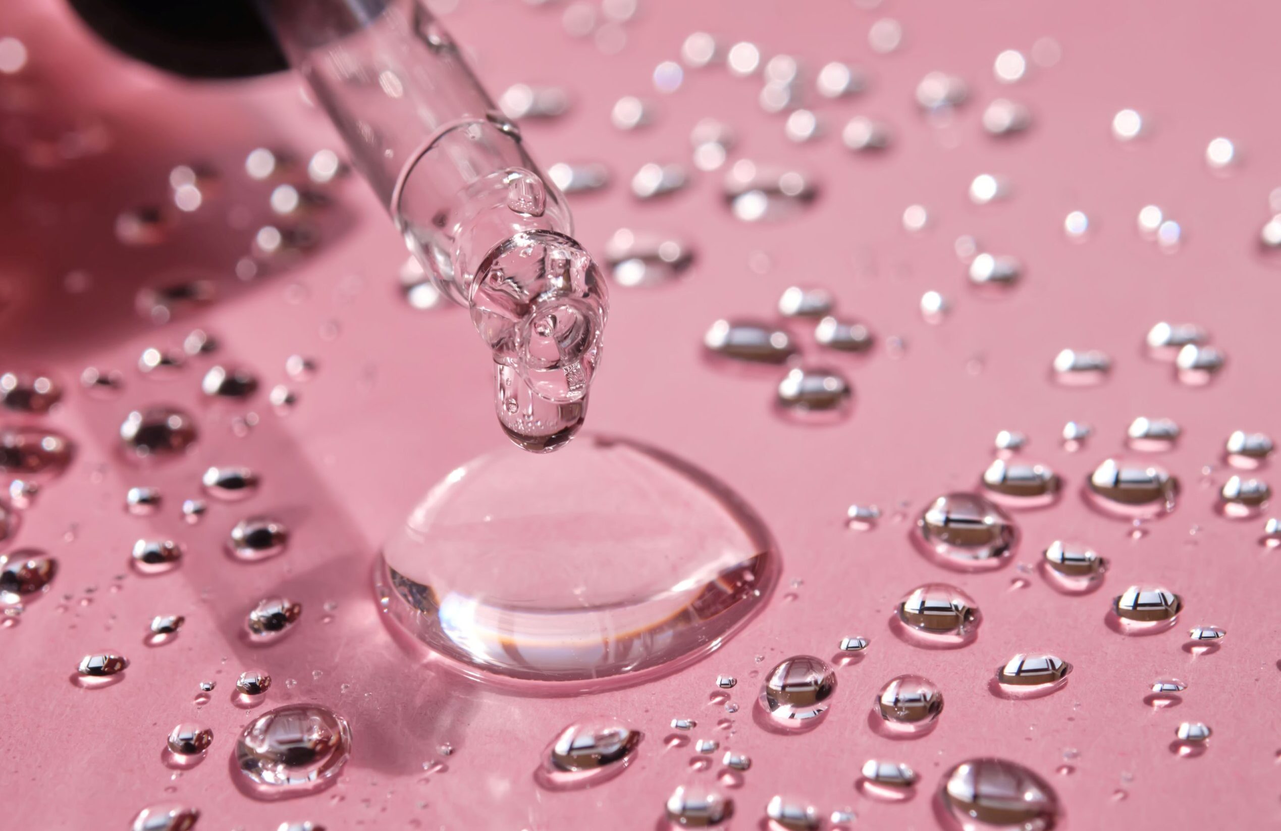 pipette-drop-splashes-micellar-water-pink-background-scaled-e1722014316753-jpg